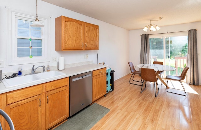 2609 Eagle Point Ct, Des Moines, IA 50320 - kitchen with dishwasher, light wood-style flooring, decorative light fixtures, a chandelier, and light countertops