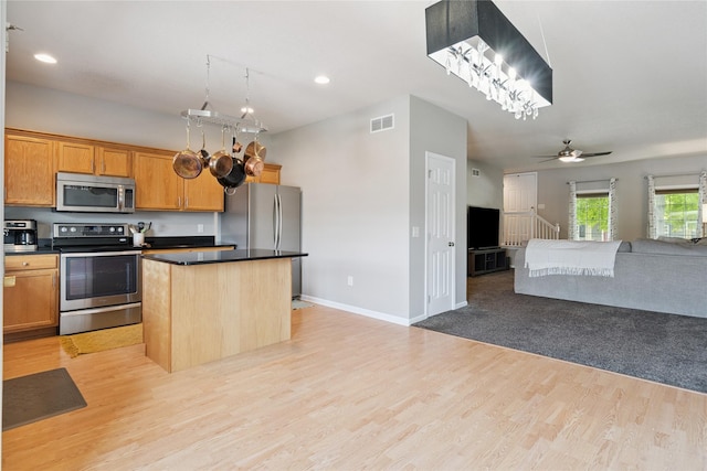 263 SE Booth Ave, Waukee, IA 50266 - kitchen featuring appliances with stainless steel finishes, open floor plan, a kitchen island, light wood-type flooring, and recessed lighting