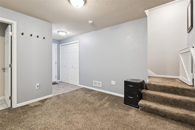 263 SE Booth Ave, Waukee, IA 50266 - basement featuring carpet floors, a textured ceiling, and stairs
