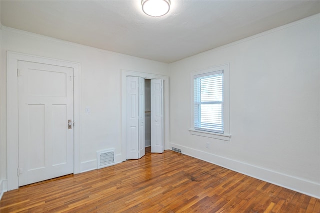 3021 49th St, Des Moines, IA 50310 - unfurnished bedroom featuring wood finished floors, crown molding, and a closet