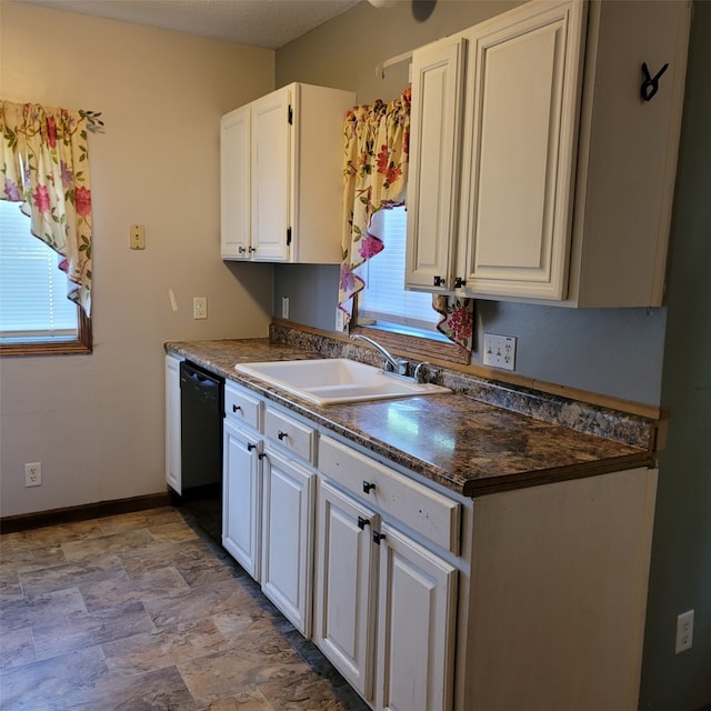 3901 3rd St, Des Moines, IA 50313 - kitchen featuring black dishwasher, healthy amount of natural light, stone finish flooring, and dark countertops