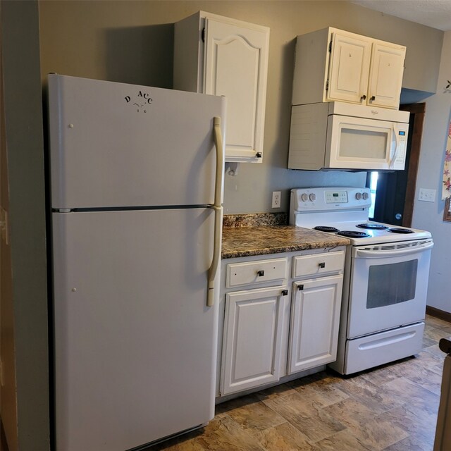 3901 3rd St, Des Moines, IA 50313 - kitchen featuring white appliances, white cabinets, stone finish flooring, and dark stone countertops