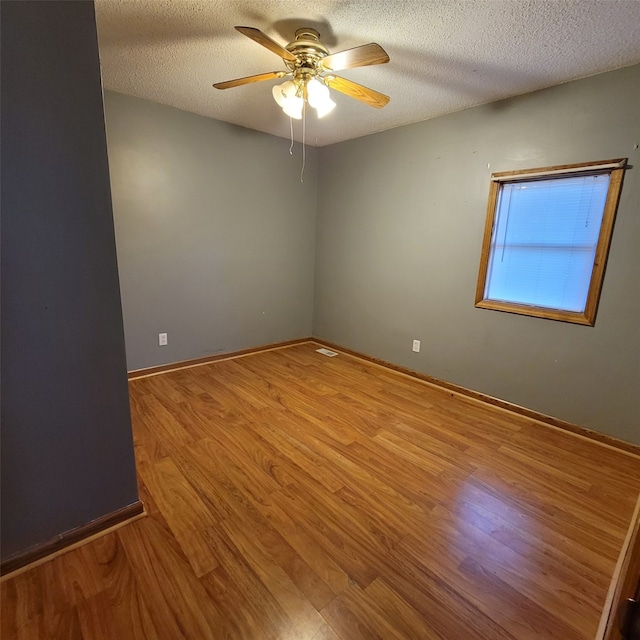 3901 3rd St, Des Moines, IA 50313 - unfurnished room featuring wood finished floors, a ceiling fan, and a textured ceiling