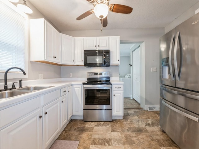 715 N Fremont St, Stuart, IA 50250 - kitchen with stainless steel appliances, washer and dryer, white cabinets, stone finish flooring, and light countertops