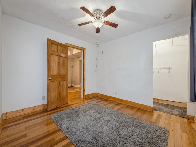 715 N Fremont St, Stuart, IA 50250 - spare room featuring light wood-type flooring, a ceiling fan, a smoke detector, and a textured ceiling