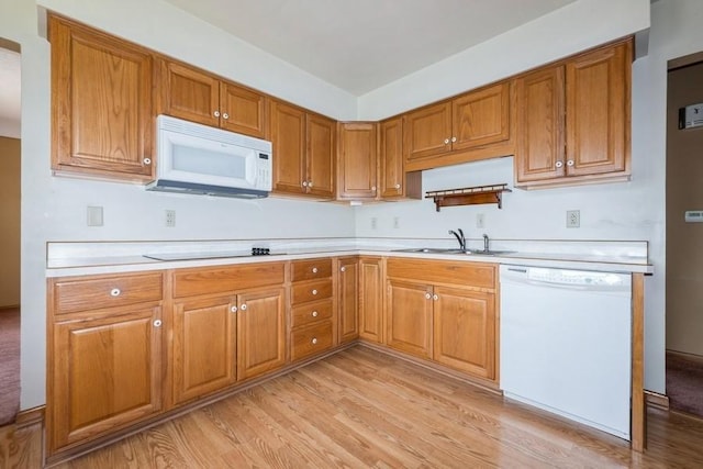 7210 Beechwood Dr, Urbandale, IA 50322 - kitchen with white appliances, brown cabinetry, light countertops, and light wood-style flooring