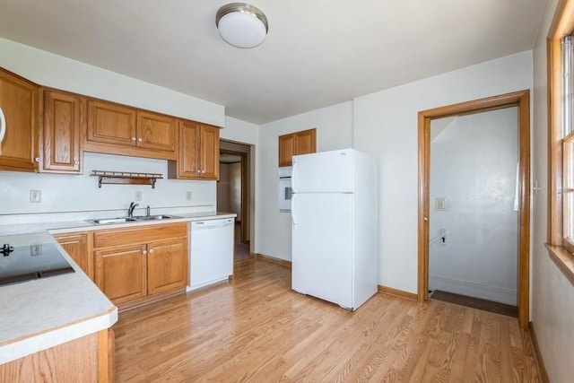 7210 Beechwood Dr, Urbandale, IA 50322 - kitchen featuring white appliances, light countertops, light wood finished floors, and brown cabinetry