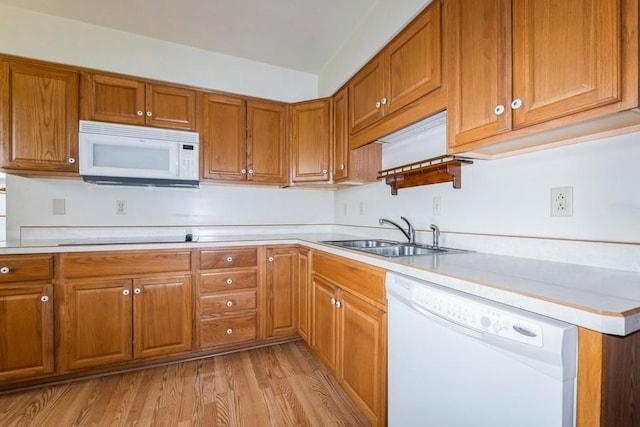 7210 Beechwood Dr, Urbandale, IA 50322 - kitchen featuring white appliances, brown cabinetry, light wood-type flooring, and light countertops