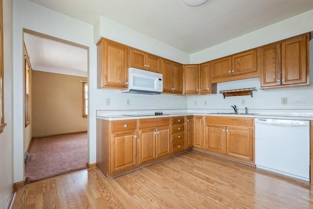 7210 Beechwood Dr, Urbandale, IA 50322 - kitchen with white appliances, light countertops, light wood-style flooring, and brown cabinets