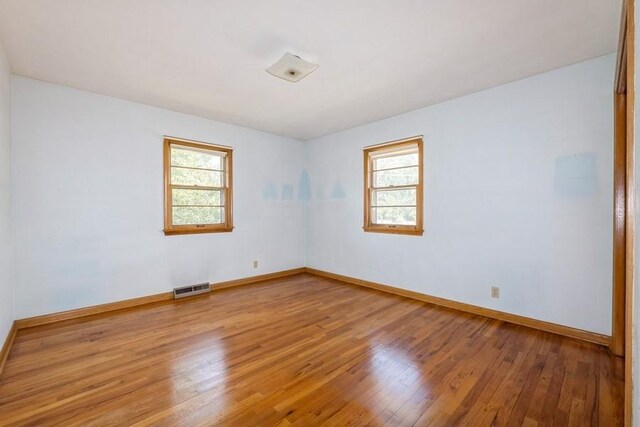 7210 Beechwood Dr, Urbandale, IA 50322 - empty room with healthy amount of natural light and wood finished floors