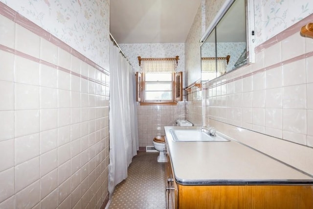 7210 Beechwood Dr, Urbandale, IA 50322 - full bath with wallpapered walls, tile walls, vanity, a shower with shower curtain, and wainscoting