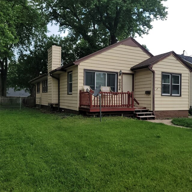 3224 SW 13th Pl, Des Moines, IA 50315 - rear view of property featuring a deck, a chimney, and a lawn