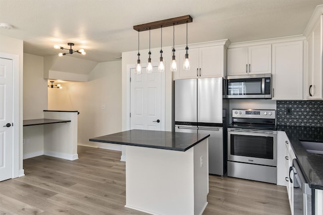 8302 Westown Pkwy Unit 1102, West Des Moines, IA 50266 - kitchen with stainless steel appliances, dark countertops, white cabinetry, and light wood finished floors