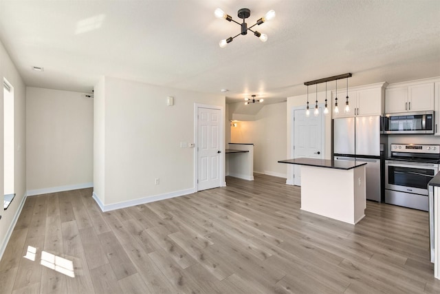 8302 Westown Pkwy Unit 1102, West Des Moines, IA 50266 - kitchen featuring stainless steel appliances, a chandelier, a center island, and light wood-type flooring