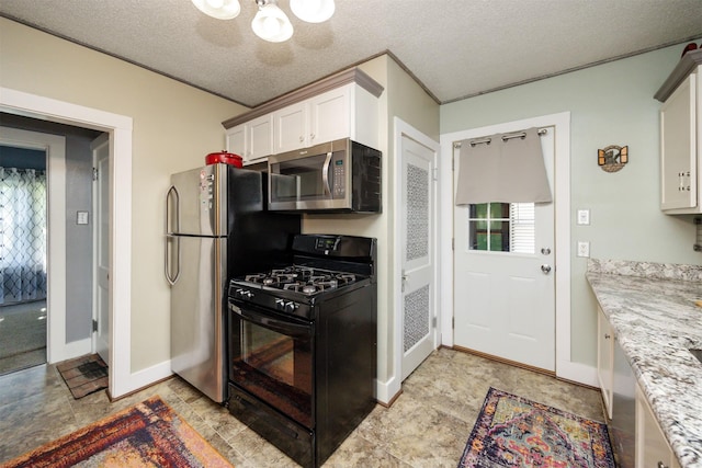 5910 Tonka Ave, Des Moines, IA 50312 - kitchen with stainless steel appliances, a chandelier, white cabinets, a textured ceiling, and light stone countertops