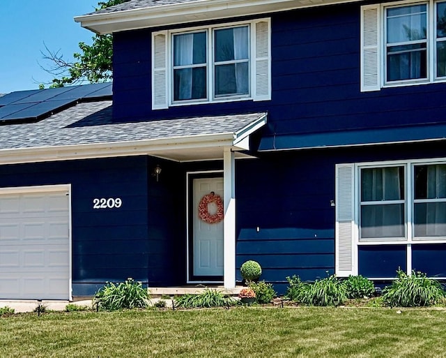 2209 4th St SW, Altoona, IA 50009 - view of exterior entry with roof with shingles, solar panels, and a yard