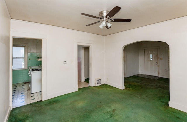802 Fulton Dr, Des Moines, IA 50315 - carpeted spare room featuring arched walkways and a ceiling fan