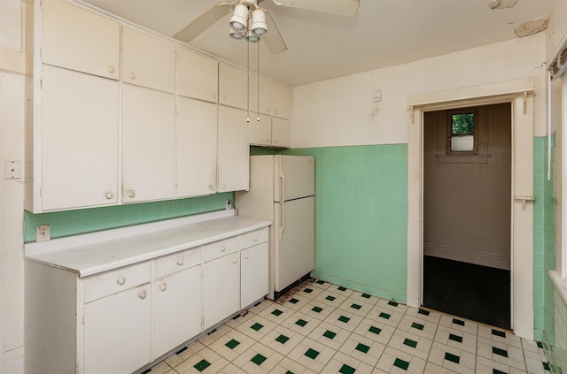 802 Fulton Dr, Des Moines, IA 50315 - kitchen featuring freestanding refrigerator, light countertops, a ceiling fan, tile walls, and a wainscoted wall