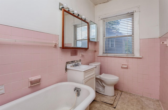 802 Fulton Dr, Des Moines, IA 50315 - full bath with tile walls, a freestanding tub, vanity, tile patterned floors, and a wainscoted wall