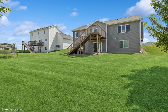 2670 Long Ave, Van Meter, IA 50261 - rear view of house featuring stairway, a trampoline, a deck, and a lawn