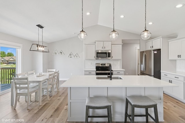 2670 Long Ave, Van Meter, IA 50261 - kitchen with appliances with stainless steel finishes, vaulted ceiling, tasteful backsplash, light wood finished floors, and light countertops