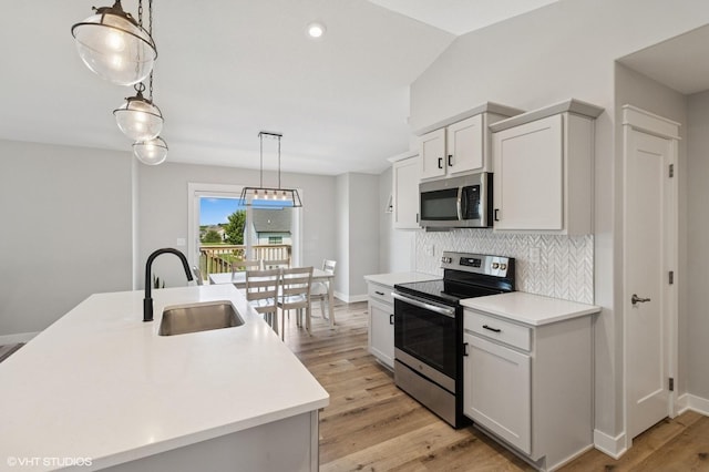 2670 Long Ave, Van Meter, IA 50261 - kitchen with appliances with stainless steel finishes, light countertops, tasteful backsplash, and hanging light fixtures