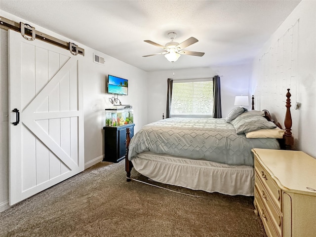 9513 University Ave Unit 12, Clive, IA 50325 - bedroom featuring a barn door, carpet flooring, and ceiling fan