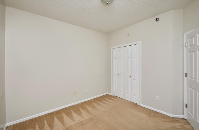 8601 Westown Pkwy Unit 5114, West Des Moines, IA 50266 - unfurnished bedroom featuring light carpet, a closet, and a textured ceiling