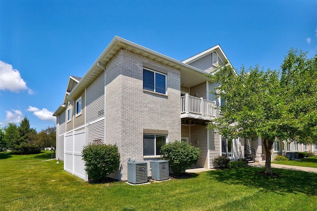 8601 Westown Pkwy Unit 5114, West Des Moines, IA 50266 - view of side of home with a balcony, brick siding, and a lawn