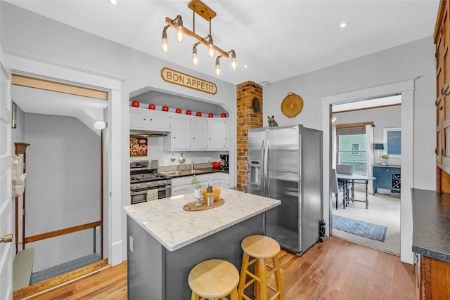 3602 64th St, Urbandale, IA 50322 - kitchen with appliances with stainless steel finishes, white cabinets, under cabinet range hood, light wood-type flooring, and recessed lighting