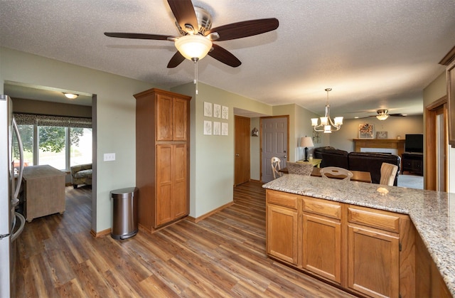 5030 Oakcreek Dr, Norwalk, IA 50211 - kitchen featuring a ceiling fan, freestanding refrigerator, wood finished floors, open floor plan, and a chandelier