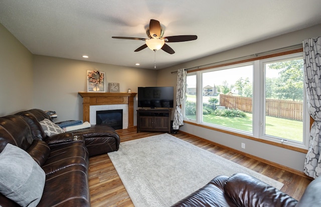 5030 Oakcreek Dr, Norwalk, IA 50211 - living room featuring a ceiling fan, plenty of natural light, light wood finished floors, a glass covered fireplace, and recessed lighting