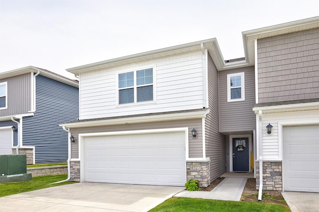 4727 170th Pl, Urbandale, IA 50323 - view of front of house featuring stone siding, an attached garage, and driveway