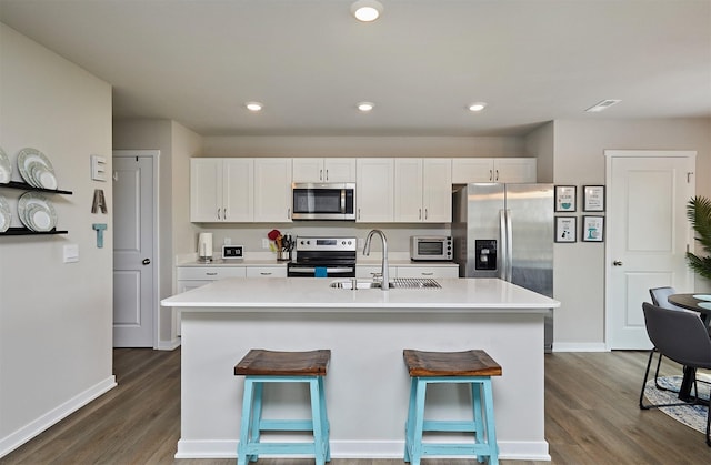 4727 170th Pl, Urbandale, IA 50323 - kitchen with appliances with stainless steel finishes, dark wood finished floors, light countertops, white cabinetry, and recessed lighting