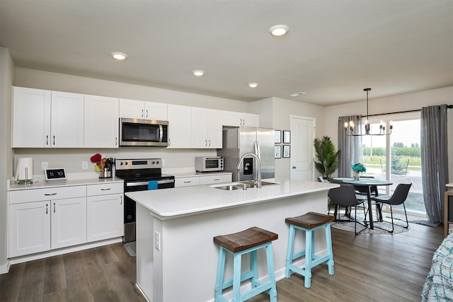 4727 170th Pl, Urbandale, IA 50323 - kitchen with appliances with stainless steel finishes, white cabinetry, dark wood-style flooring, a center island with sink, and recessed lighting