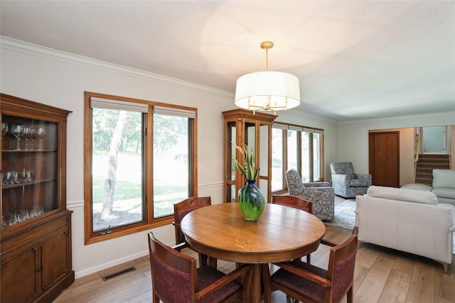 1711 Plaza Cir, Windsor Heights, IA 50324 - dining room featuring plenty of natural light, light wood-style floors, crown molding, stairway, and a chandelier