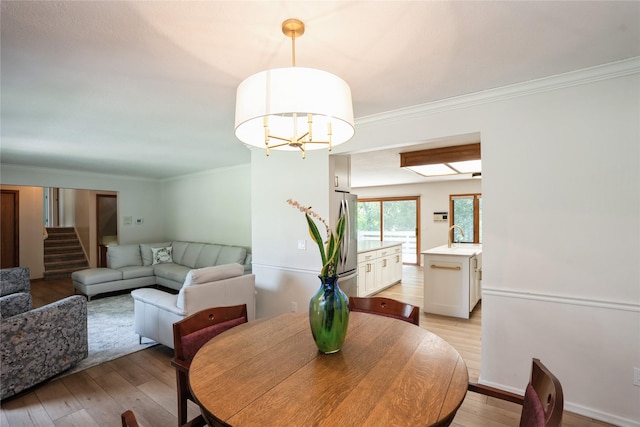 1711 Plaza Cir, Windsor Heights, IA 50324 - dining room with light wood-type flooring, ornamental molding, stairs, and a chandelier