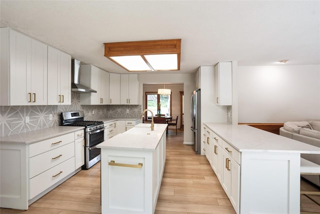 1711 Plaza Cir, Windsor Heights, IA 50324 - kitchen with appliances with stainless steel finishes, wall chimney exhaust hood, a center island with sink, a peninsula, and light wood finished floors