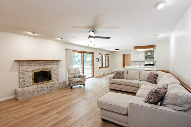 1711 Plaza Cir, Windsor Heights, IA 50324 - living room with a ceiling fan, a brick fireplace, and light wood-type flooring