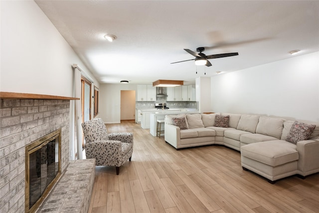 1711 Plaza Cir, Windsor Heights, IA 50324 - living area featuring a fireplace, a ceiling fan, and light wood-style floors