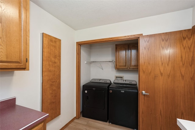 1711 Plaza Cir, Windsor Heights, IA 50324 - laundry room with washing machine and dryer, cabinet space, and light wood-style floors