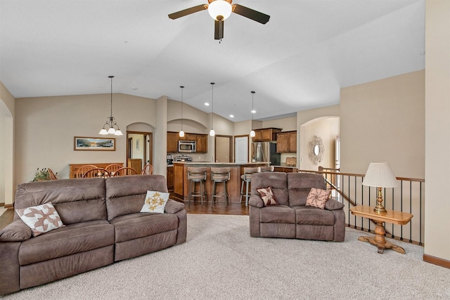 6054 Bradford Ln, Johnston, IA 50131 - carpeted living room featuring arched walkways, a ceiling fan, vaulted ceiling, recessed lighting, and a chandelier