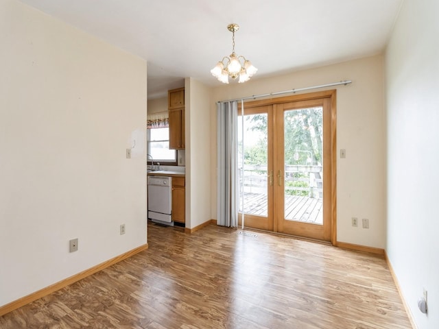 1122 E Ave E, Albia, IA 52531 - unfurnished room featuring french doors, a chandelier, and light wood-style floors