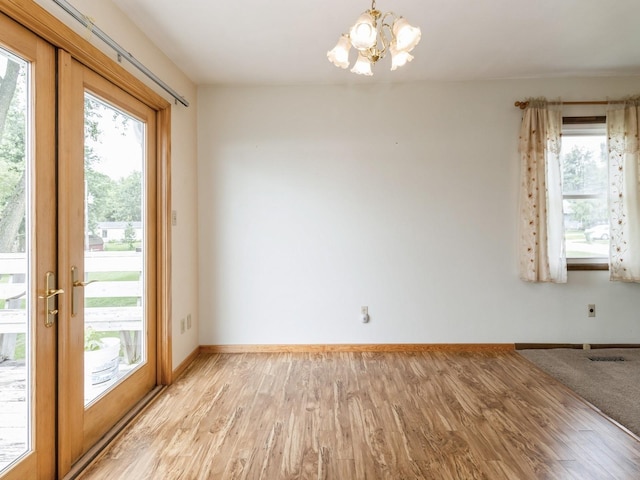 1122 E Ave E, Albia, IA 52531 - unfurnished room featuring a chandelier and light wood-style flooring