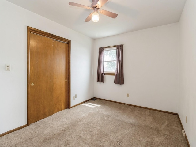 1122 E Ave E, Albia, IA 52531 - unfurnished bedroom with carpet floors, a closet, and a ceiling fan