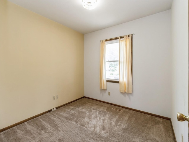 1122 E Ave E, Albia, IA 52531 - spare room featuring carpet flooring and baseboards
