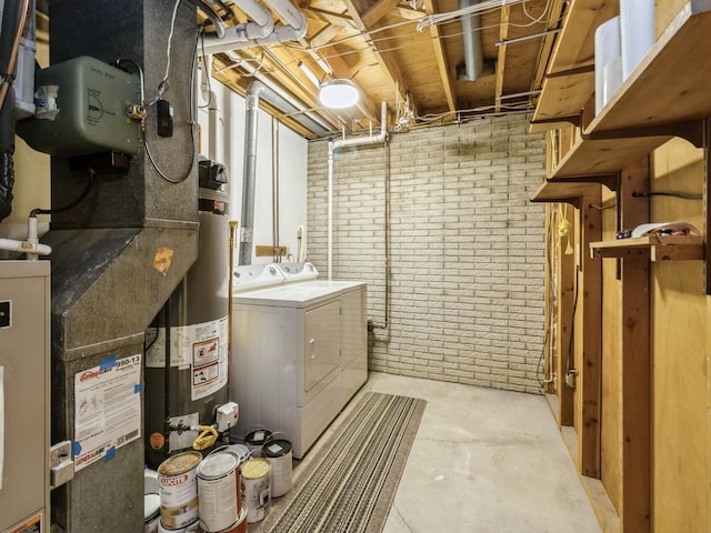 1122 E Ave E, Albia, IA 52531 - unfinished below grade area featuring washer and clothes dryer, gas water heater, brick wall, and heating unit