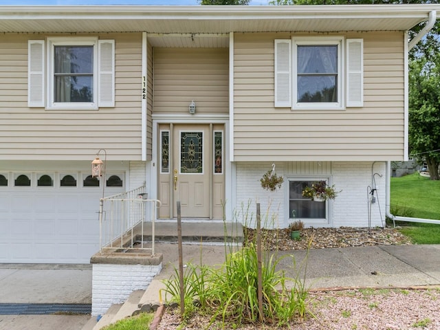 1122 E Ave E, Albia, IA 52531 - bi-level home with a garage and brick siding