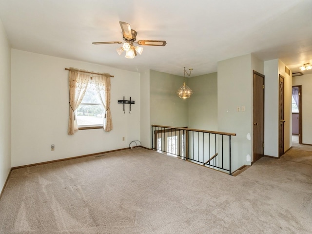 1122 E Ave E, Albia, IA 52531 - carpeted empty room featuring ceiling fan and a chandelier