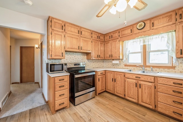 4326 E Washburn Rd, Waterloo, IA 50702 - kitchen with appliances with stainless steel finishes, light wood-style floors, and light countertops